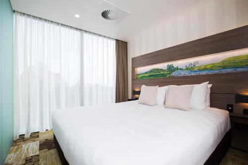 a large white bed in a hotel room at Novotel New Plymouth Taranaki in New Plymouth