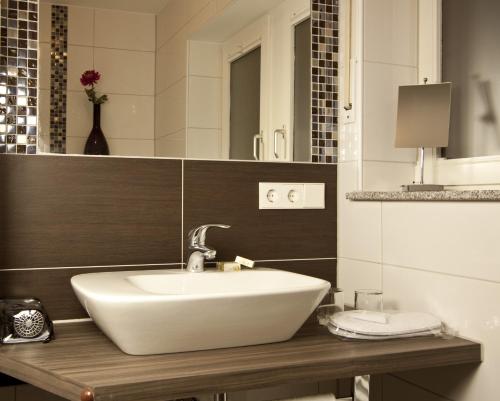 a bathroom with a white sink and a mirror at Lupinenhotel Bodensee in Sipplingen