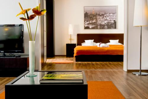 a living room with a bed and a coffee table at Wyndham Hannover Atrium in Hannover