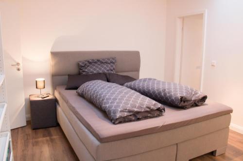 a bed with two pillows on it in a room at White Lofty und White Studio in Düsseldorf