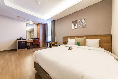 a hotel room with a large bed and a desk at WD Hotel in Seoul