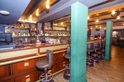 a bar with a row of bar stools at Lytton Hotel in Kolkata