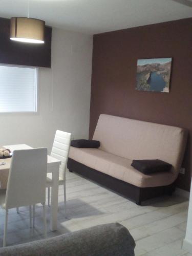 a living room with a bed and a table and chairs at Apartamento Buendia in Buendía