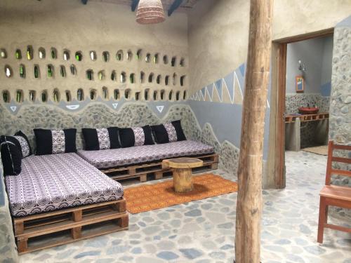 uma sala de estar com dois bancos e uma mesa em Cocoa Village Guesthouse em Obo