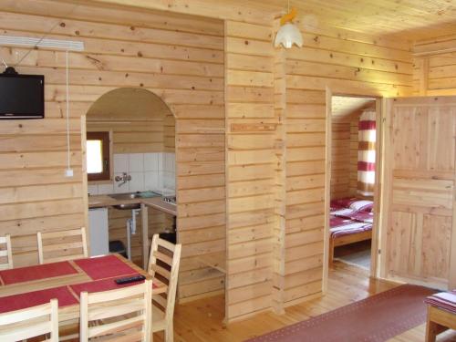 una cucina e una sala da pranzo con parete in legno di Domki "Na Dworskiej" Polańczyk 696-025-331 a Polańczyk