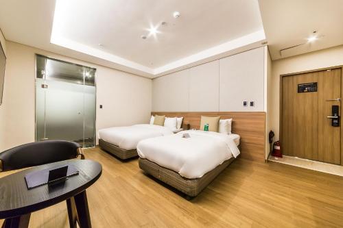 a hotel room with two beds and a table at WD Hotel in Seoul