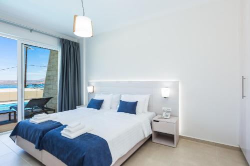 a bedroom with a large bed with a view of the ocean at Sun and Sea Plus Resort in Plaka