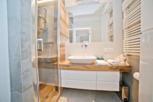 a bathroom with a sink and a shower at Grand Apartments Tartaczna Deluxe in Gdańsk