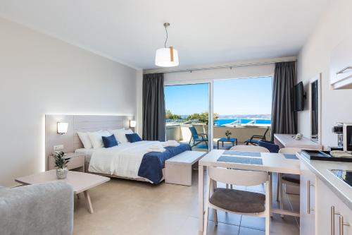 a bedroom with a bed and a kitchen and a living room at Sun and Sea Plus Resort in Plaka