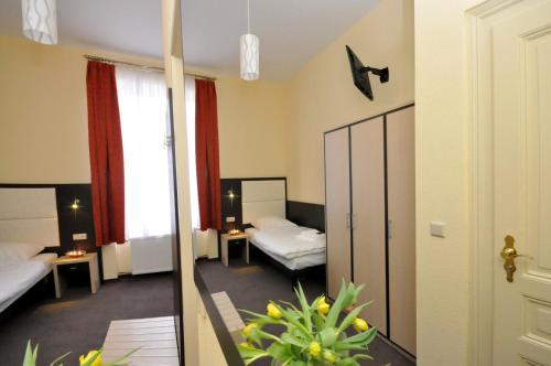 フランクフルト・アム・マインにあるホテル ボヴァのベッド2台と鏡が備わるホテルルームです。