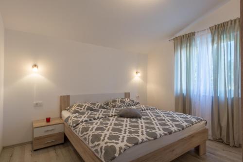 a bedroom with a bed and a large window at Apartman Berto in Vrsi