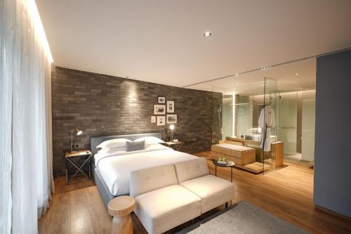 a bedroom with a large white bed and a bathroom at Ad Lib Hotel Bangkok in Bangkok