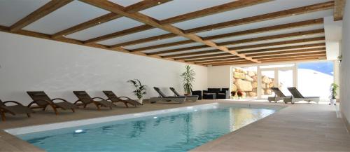 uma sala de estar com uma piscina com cadeiras e uma piscina em Agriturismo Anví em Badia