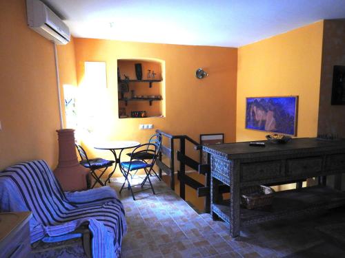 a living room with yellow walls and a table and chairs at Blue Bench Krk in Krk