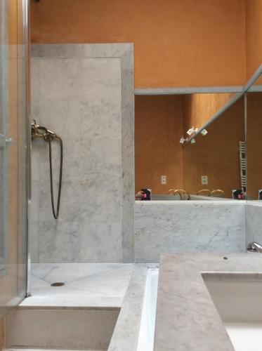 een badkamer met een douche, een wastafel en een spiegel bij Mas Des Graviers in Pourrières
