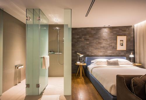 a bedroom with a bed and a glass shower at Ad Lib Hotel Bangkok in Bangkok