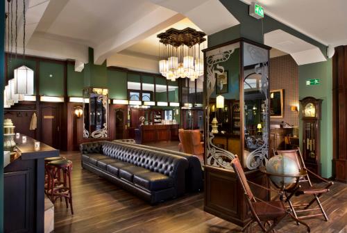 a waiting room with a leather couch and chairs at Tryp by Wyndham Kassel City Centre in Kassel