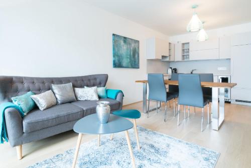 salon z szarą kanapą i niebieskimi krzesłami w obiekcie Vienna Residence | Spacious Serviced Apartment in Vienna directly at the U4 w Wiedniu
