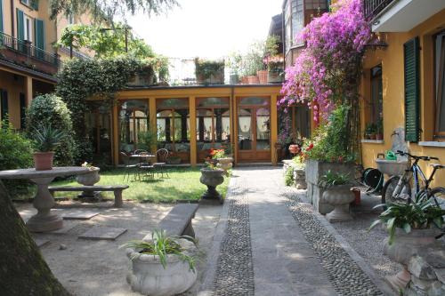 einen Innenhof eines Gebäudes mit Pflanzen und Blumen in der Unterkunft Hotel Centrale Bellagio in Bellagio
