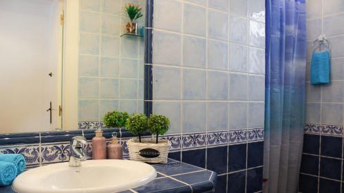シッチェスにあるSitges Apartmentの青いタイル張りのバスルーム(シンク、シャワー付)