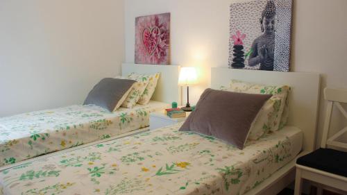 シッチェスにあるSitges Apartmentのベッドルーム1室(ベッド2台、ランプ付きテーブル付)