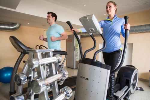 a man and a woman on a treadmill in a gym at Hotel & Restaurant Goldener Pflug in Ludwigsburg