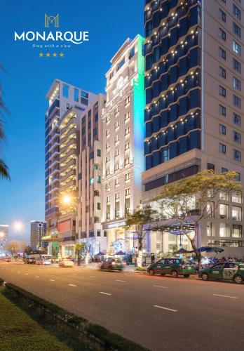 a city street at night with tall buildings at Monarque Hotel Danang in Da Nang