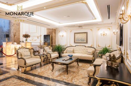 a living room with a couch and chairs and a table at Monarque Hotel Danang in Da Nang