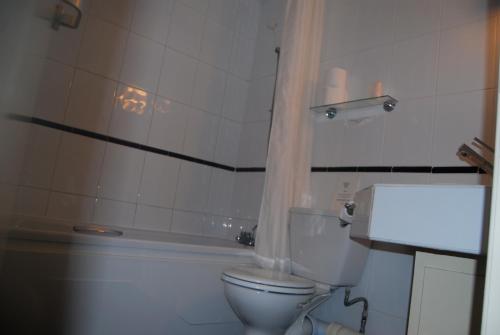 a bathroom with a toilet and a bath tub at Brecon Hotel Sheffield Rotherham in Rotherham