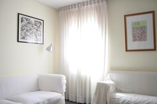 a living room with a white couch and a window at Bocca di Piazza in Venice