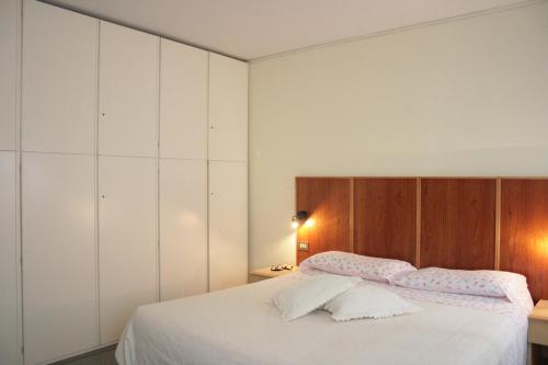 a bedroom with a large white bed with wooden cabinets at Bocca di Piazza in Venice