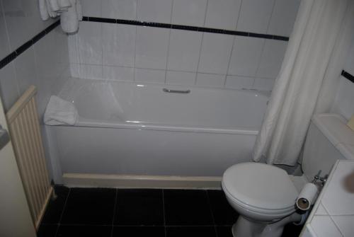 a bathroom with a white tub and a toilet at Brecon Hotel Sheffield Rotherham in Rotherham