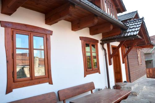 a wooden bench and windows on a building at Penzion v Podhradí in Štramberk