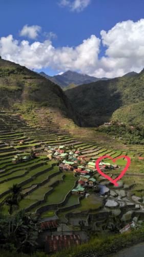 a view of a town in a valley with mountains at BATAD CRISTINA'S Main Village INN & Restaurant in Banaue