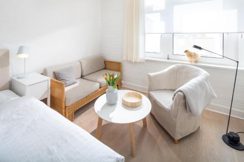 a bedroom with a bed and a couch and a table at Ferien Domizil 25 in Norderney