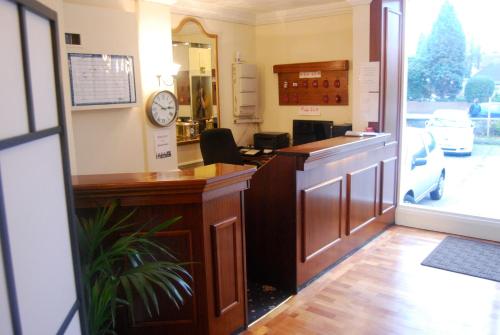 a office with a desk with a clock on the wall at Brecon Hotel Sheffield Rotherham in Rotherham