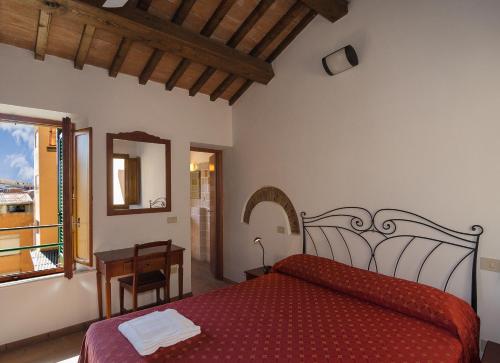 a bedroom with a red bed and a mirror at Helvetia Pisa Tower in Pisa
