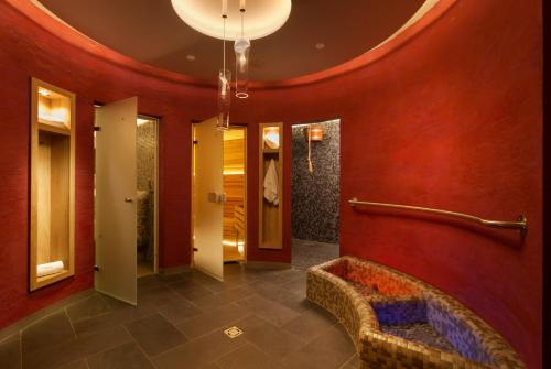 a lobby with red walls and a couch in a hallway at Grand Apartments Špindlerův Mlýn in Špindlerův Mlýn