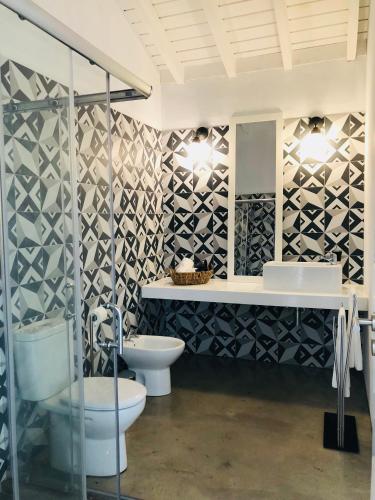 a bathroom with two toilets and a sink and a mirror at Casa da Rocha in Terra do Pão