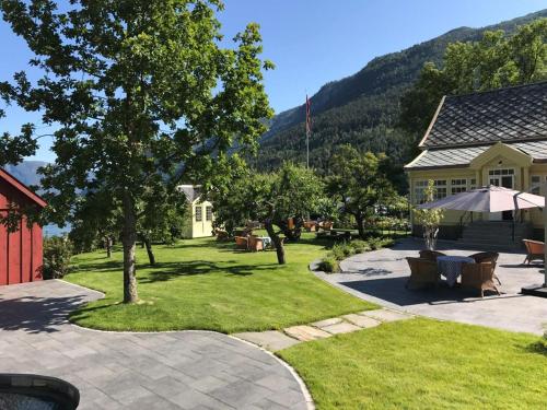 a yard with a patio with chairs and an umbrella at Walaker Hotel in Solvorn