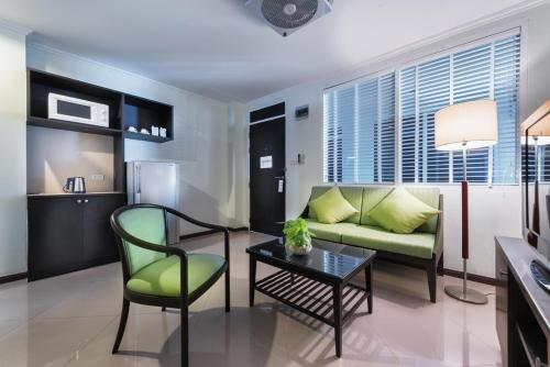 a living room with a couch and a table at Capital Mansion - SHA Certified in Bangkok