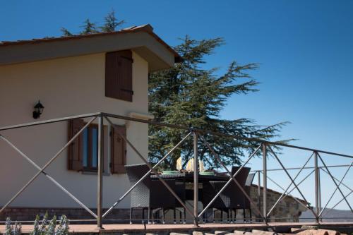 a house with a balcony and chairs in front of it at Tenuta il Poggetto in Radda in Chianti