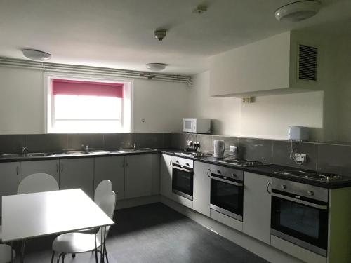 ロンドンにあるLeinster House (Bayswater)の白い家電製品、テーブル、窓が備わります。