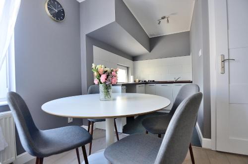 ソポトにあるVictus Apartamenty, Apartament Tangoの白いテーブルと椅子、花瓶