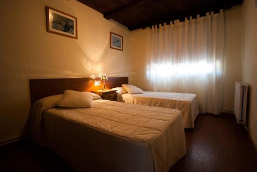 a hotel room with two beds and a window at Los Arribes in Moralina