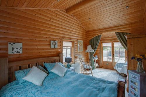 a bedroom with a bed in a log cabin at Balnabrechan Lodge in Arbroath