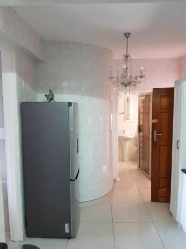 a kitchen with a stainless steel refrigerator in a room at Beach frond apartment in Amanzimtoti