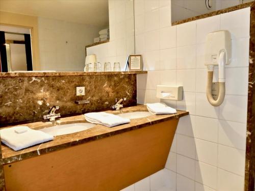 a bathroom with a sink and a mirror at Golden Tulip Hotel de’ Medici in Bruges