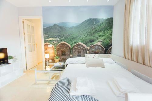 1 dormitorio con 1 cama grande y vistas a la montaña en One & Lux- Lagar, en Sevilla