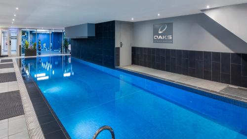 a swimming pool with blue water in a building at Oaks Melbourne on Market Hotel in Melbourne